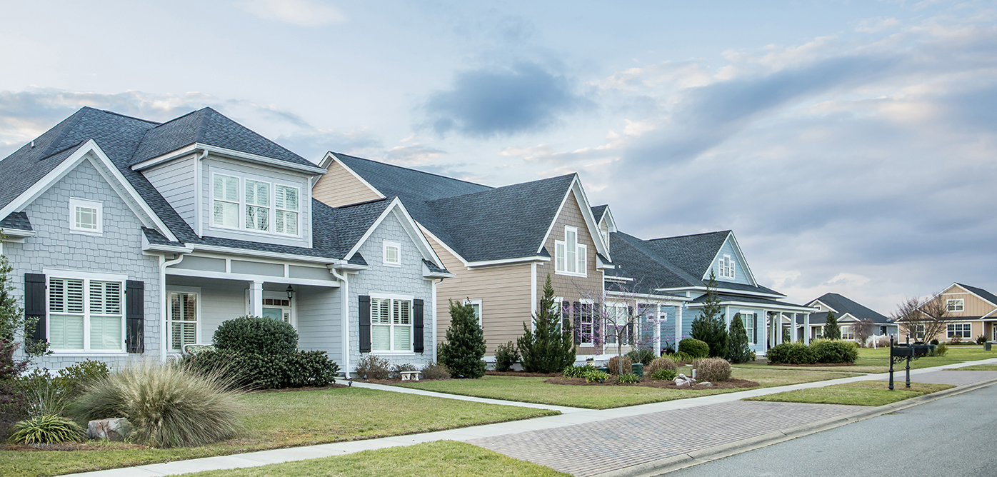 A street view of a new construction neighborhood with larger lan