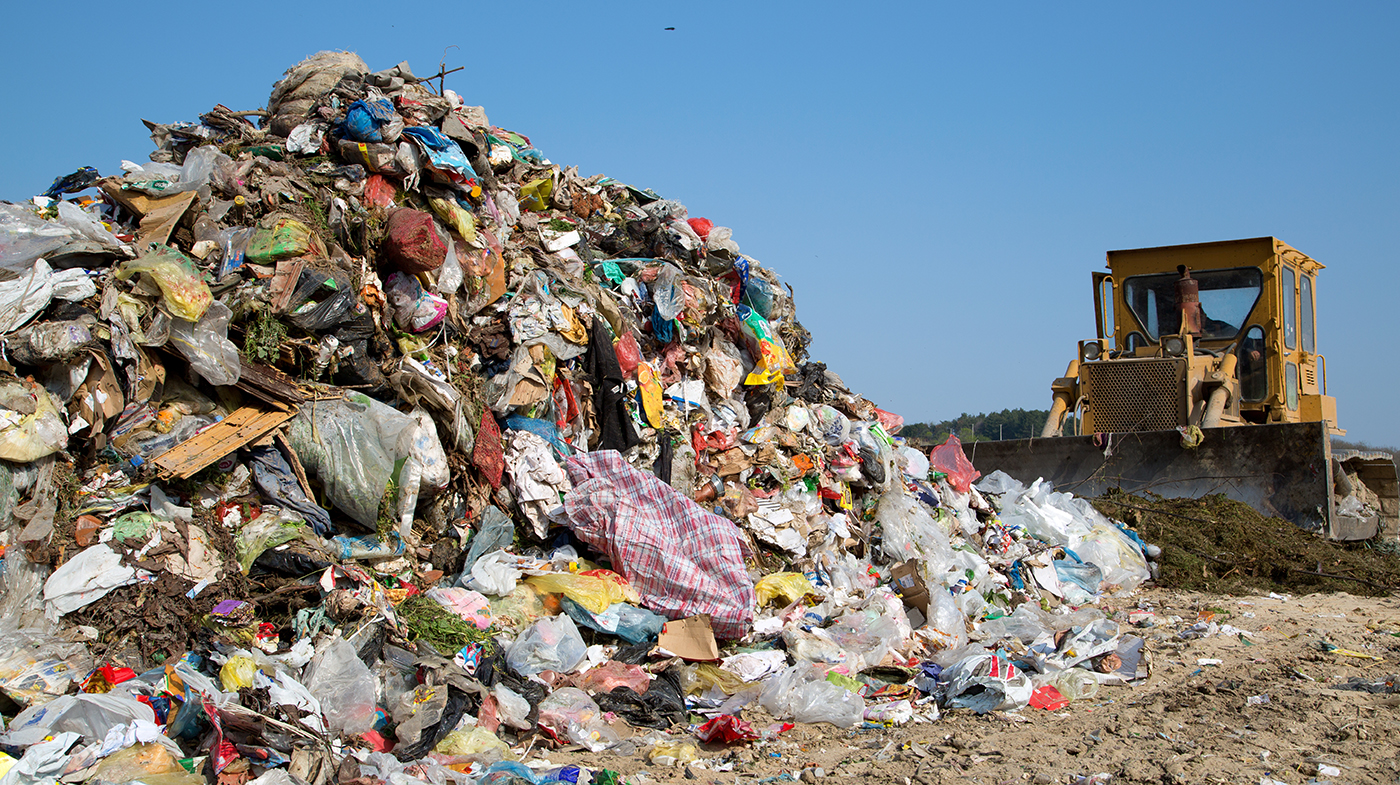 The old bulldozer moving garbage in a landfill