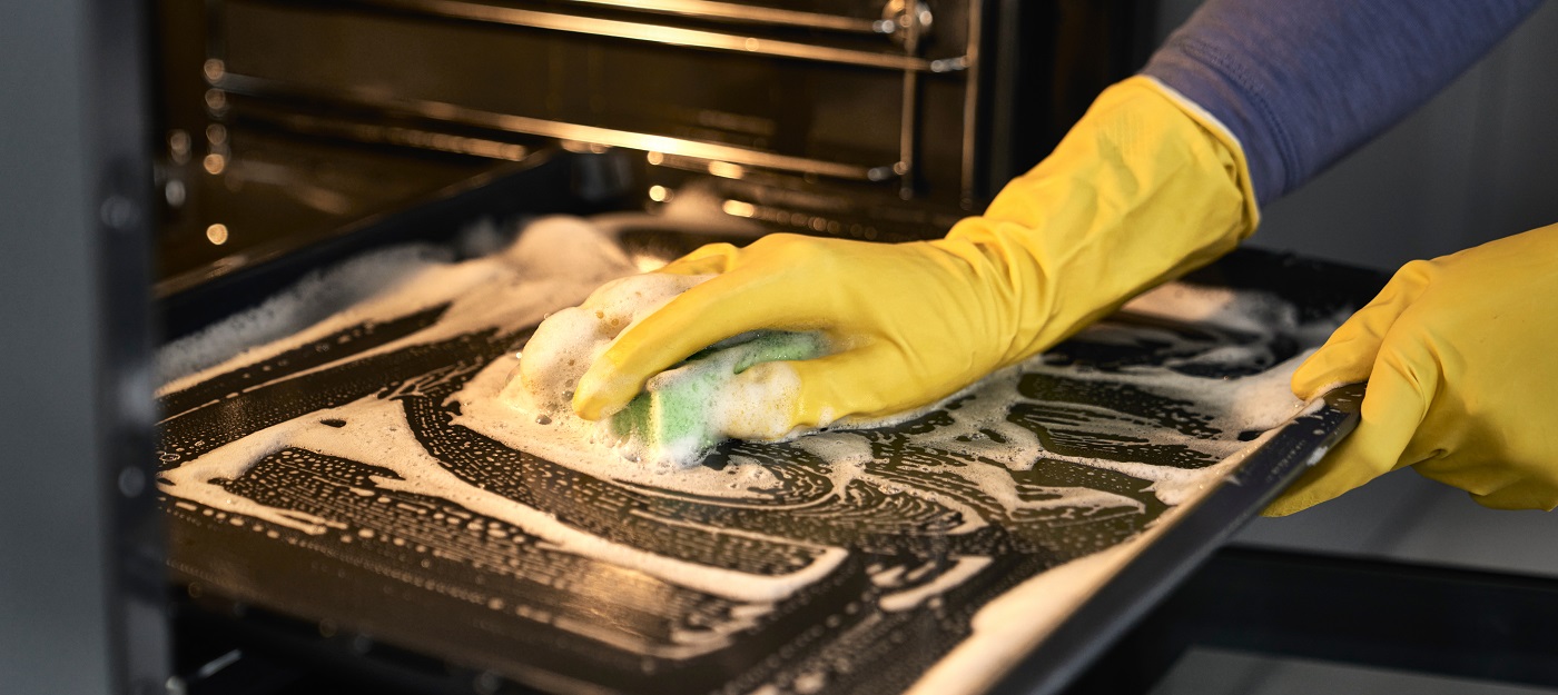 Close-up of woman cleaning oven at home