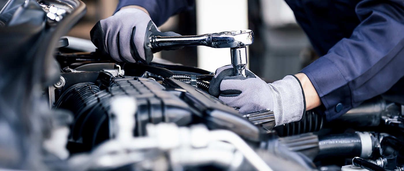 Professional mechanic working on the engine of the car in the ga