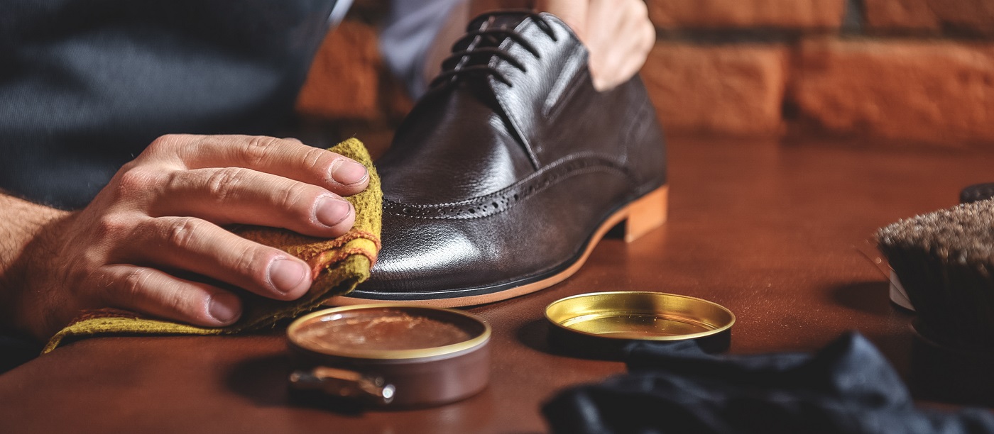 man shining shoes with a rag